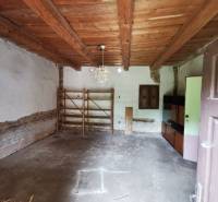 Interior of a family house with a wooden ceiling, simple shelf, and cabinet.