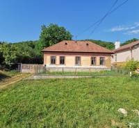 A family house on a street in Nitrianske Sučany, surrounded by a green plot and nature.