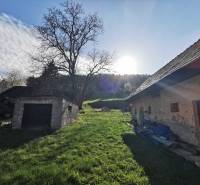 A grassy plot with a family house and an old garage on Nirtrianska Street in Nitrianske Sučany.