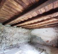 The interior of the family house has stone walls and a wooden ceiling.
