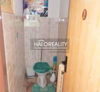 Bathroom in a family house with a toilet and a green seat.