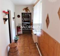 A hallway in a family house with wooden paneling, floral decoration, and a wicker basket.