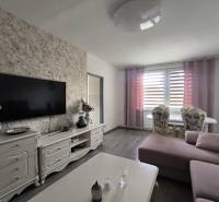 Living room in a 3-room apartment with a TV, sofa, and dining table.
