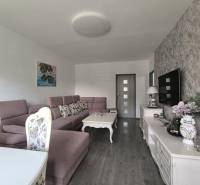 Living room in a 3-room apartment, with a sofa, decorative furniture, and a TV on the wall.