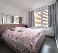 A bedroom in a 3-room apartment with a large bed and a floral bedspread.