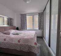 Bedroom in a 3-room apartment with a large bed, built-in wardrobe, and a window with curtains.