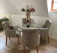 Dining area with a round table and stylish chairs in a 2-room apartment.