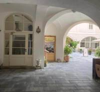 Historic courtyard with arcades, commercial space, and café bar in Banská Štiavnica.