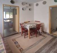 Interior of a family house with a dining room, decorative walls, and basic furnishings.