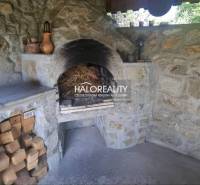 A stone fireplace in the interior of a family house, surrounded by woods and ceramic decorations.