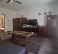 Living room in a family house with furniture and a television, light-colored walls.
