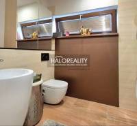 Bathroom in a family house with a sink, mirror, washing machine, and dryer.