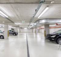 Parking spaces in garages with parked cars, lighting and ventilation systems.