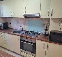 Kitchen in a 3-room apartment with a gas stove and sink, wooden countertop.