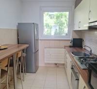 A kitchen in a 3-room apartment with a bar counter and appliances, bright atmosphere.