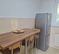 A kitchen with a bar table and a refrigerator in a 3-room apartment.