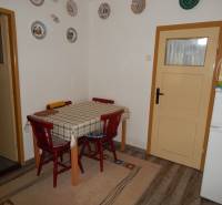 Dining room in a cottage with a wooden table and round decorations on the wall.