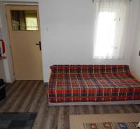 A cabin with a comfortable sofa, a carpet, and doors leading to another room.