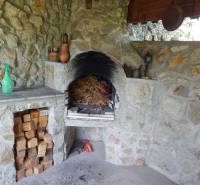 A stone fireplace in a cabin with wood stored in a stone alcove.