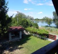 A garden with a gazebo by the lake and greenery from the cottage in Klížska Nemá.