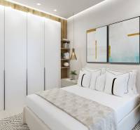 Bright bedroom in a 3-room apartment with white wardrobes and colorful paintings.