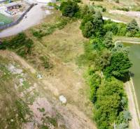 Aerial view of development plots in Záhradné with a nearby football field and pond.