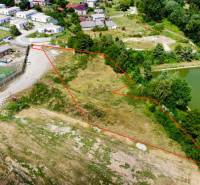 Development plots in Záhradné near a lake, sports field, and residential houses.