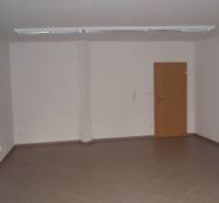 An empty office space with brown tiles and wooden doors.