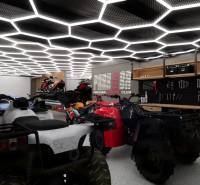 Interior of a commercial space with stored vehicles and tools, futuristic ceiling light decoration.