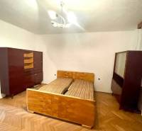 A bedroom in a family house with older furniture and a wooden floor.