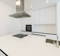 A kitchen in a 3-room apartment with white cabinets, a cooktop, and a sink.