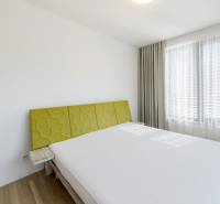 Bright bedroom with a large window and a bed in a 3-room apartment.