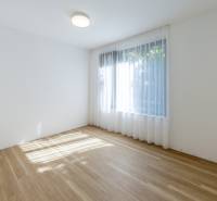 An empty room with a window and a wooden decor floor in a 3-room apartment.