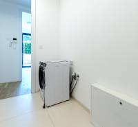 White laundry room with a dishwasher in a 3-room apartment, floor with wood decor.