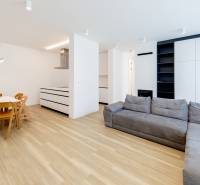 Living room of a three-room apartment with a wooden decor floor and a corner sofa.