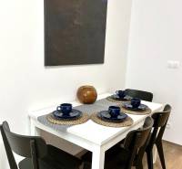 Dining table with four chairs, a painting on the wall in a 2-room apartment.