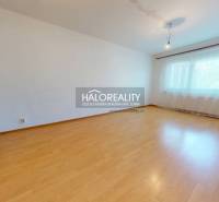 A room with a wooden floor and a brick wall in a 4-room apartment.