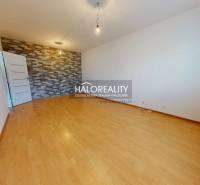 A room in a 4-room apartment with a parquet floor and a decorative brick wall.