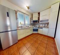 A kitchen in a 4-room apartment with a modern kitchen unit and a refrigerator.