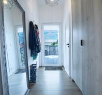 Hallway in a family house with a large mirror, coat racks, and a wardrobe.