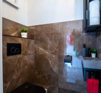 A bathroom in a family house with brown tiles and practical storage space.