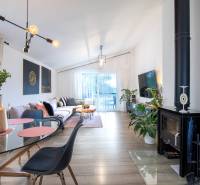 Living room of a family house with a fireplace, comfortable sofa, and glass table.