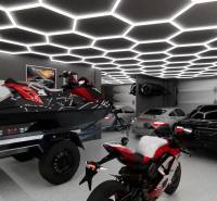 Showroom with cars, a motorcycle, and a jet ski under hexagonal lighting.