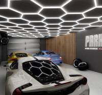 Commercial premises with a garage, luxury cars, impressive lighting, and decorations on the walls.