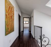 Interior of a family house with a painting on the wall, dark floor, railing.