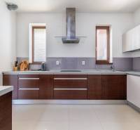 A kitchen in a family house with appliances and wooden cabinets.
