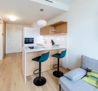 A kitchen with a bar counter and stools in a 2-room apartment, a picture of the universe on the wall.