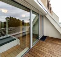 A rooftop terrace with a wooden floor and glazing in a 2-room apartment.