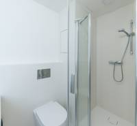 Bathroom with a shower and toilet in a 2-room apartment.