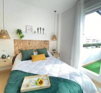 A bright bedroom with a bed, decorations, and access to the balcony in a 3-room apartment.